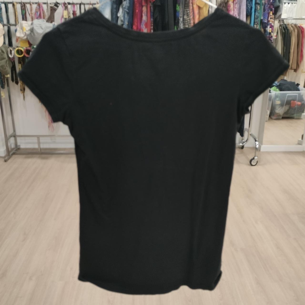Black t-shirt on a hanger in a store setting