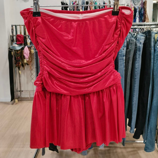 Red strapless dress hanging on a rack in a store setting
