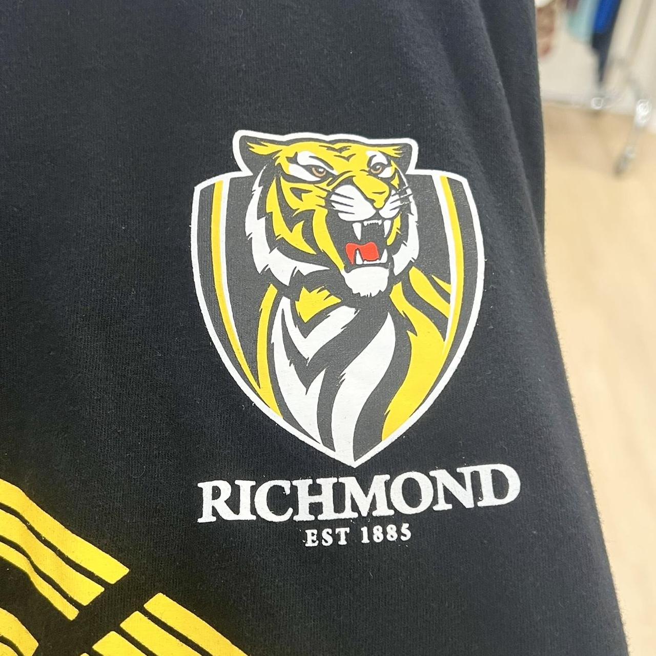 Black t-shirt with a yellow and white tiger logo and 'Richmond' text on a blurred background