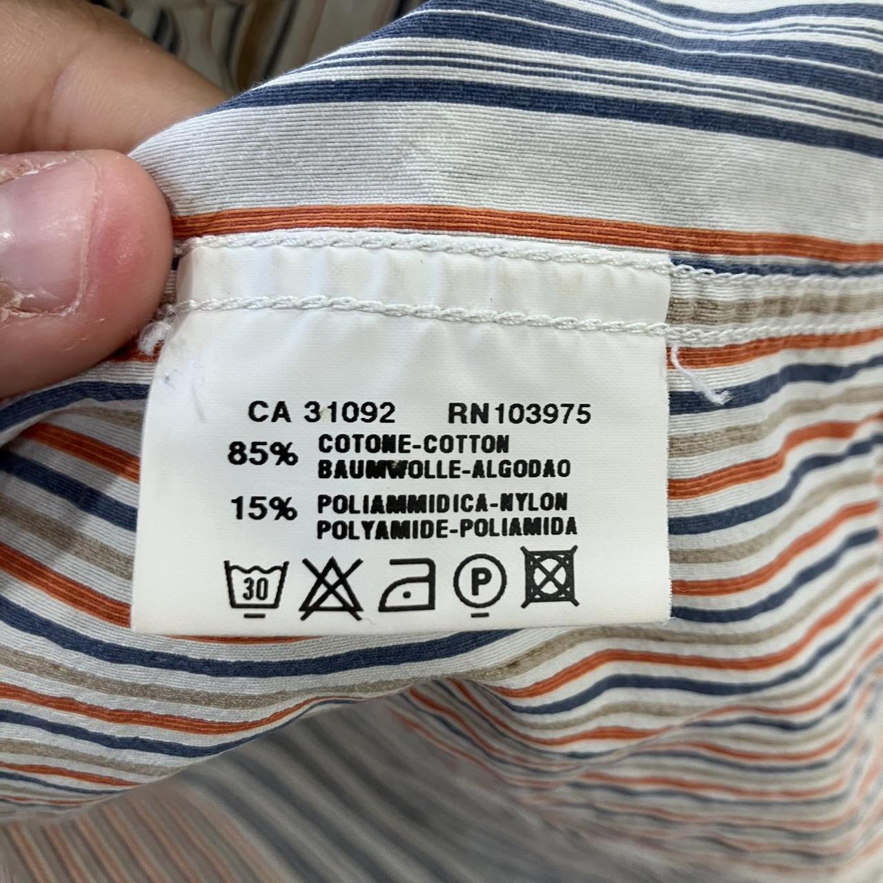 Clothing label with text and symbols on a striped fabric background