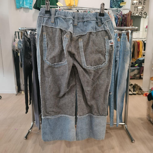 Pair of patchwork jeans hanging on a rack in a store setting