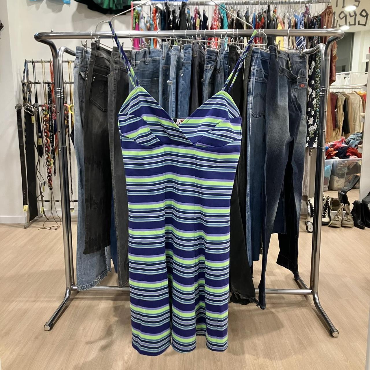 Striped dress hanging on a rack with jeans in a store setting