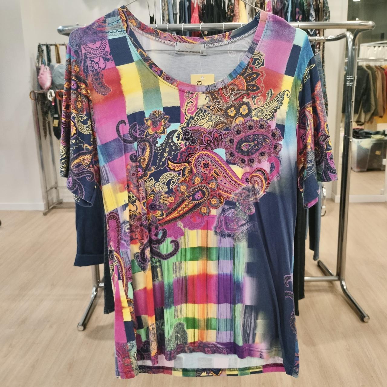 Colorful paisley and plaid short sleeve shirt on hanger, second hand fashion store setting