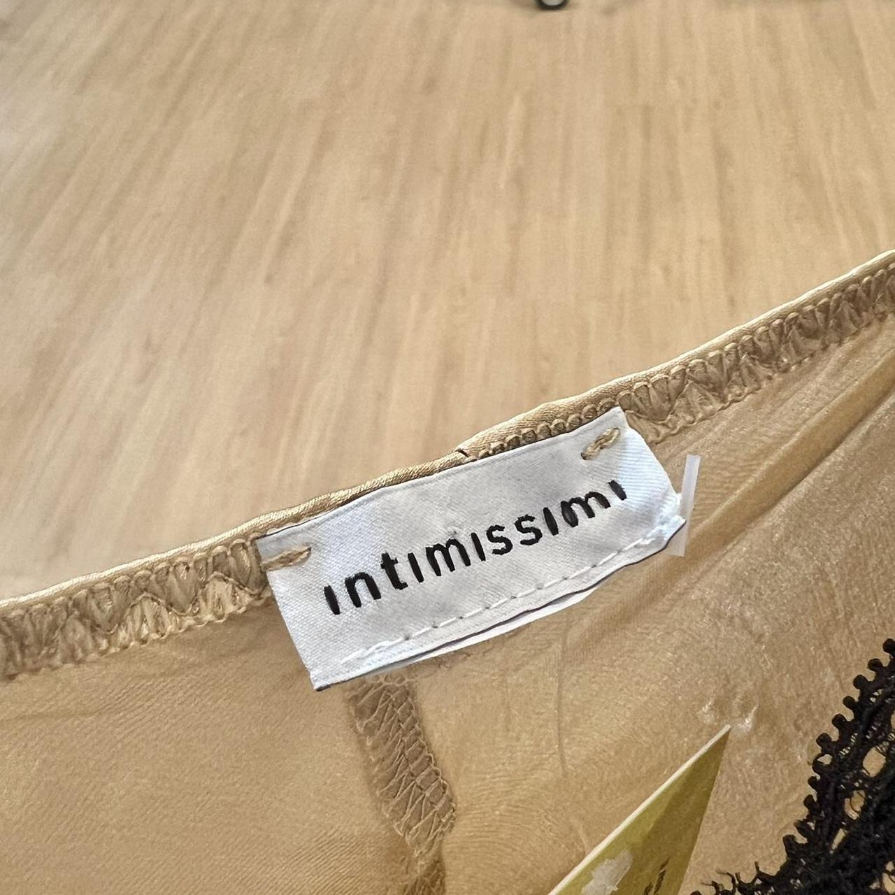 Close-up of beige mesh lingerie label with stitched brand tag on wood floor background