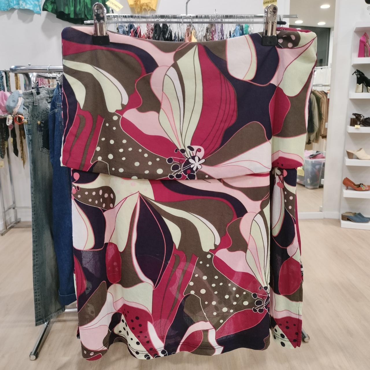 Colorful floral-patterned skirt hanging on a rack in a store setting