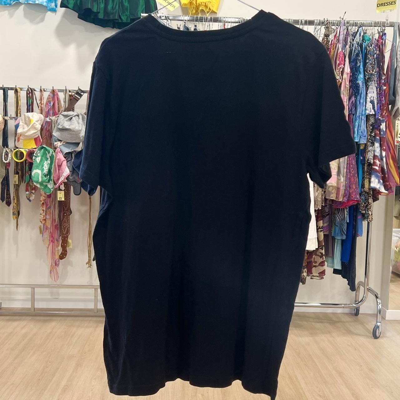 Black t-shirt on a rack with clothing in the background
