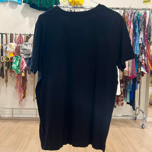 Black t-shirt on a rack with clothing in the background