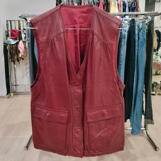 Red leather vest on a rack with clothing in the background