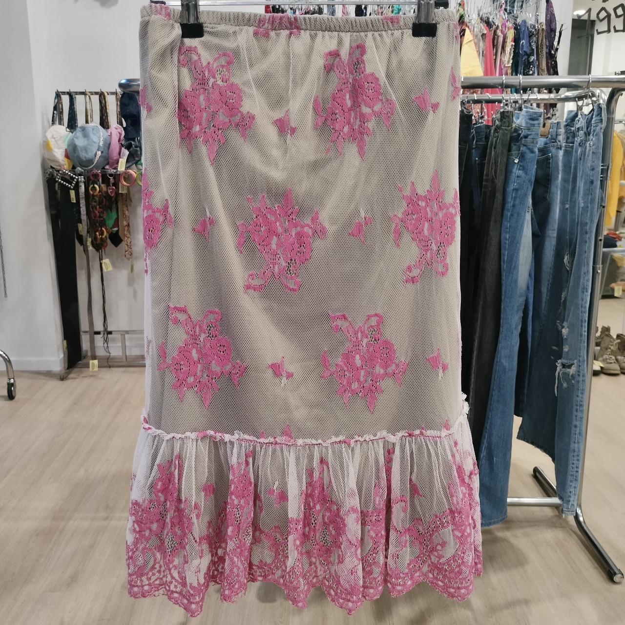 Floral lace skirt with pink flowers on a rack in a store setting