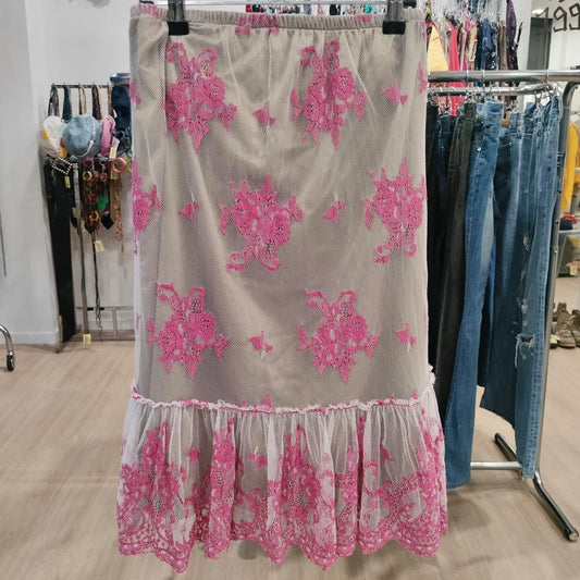 Floral lace skirt with pink flowers on a rack in a store setting