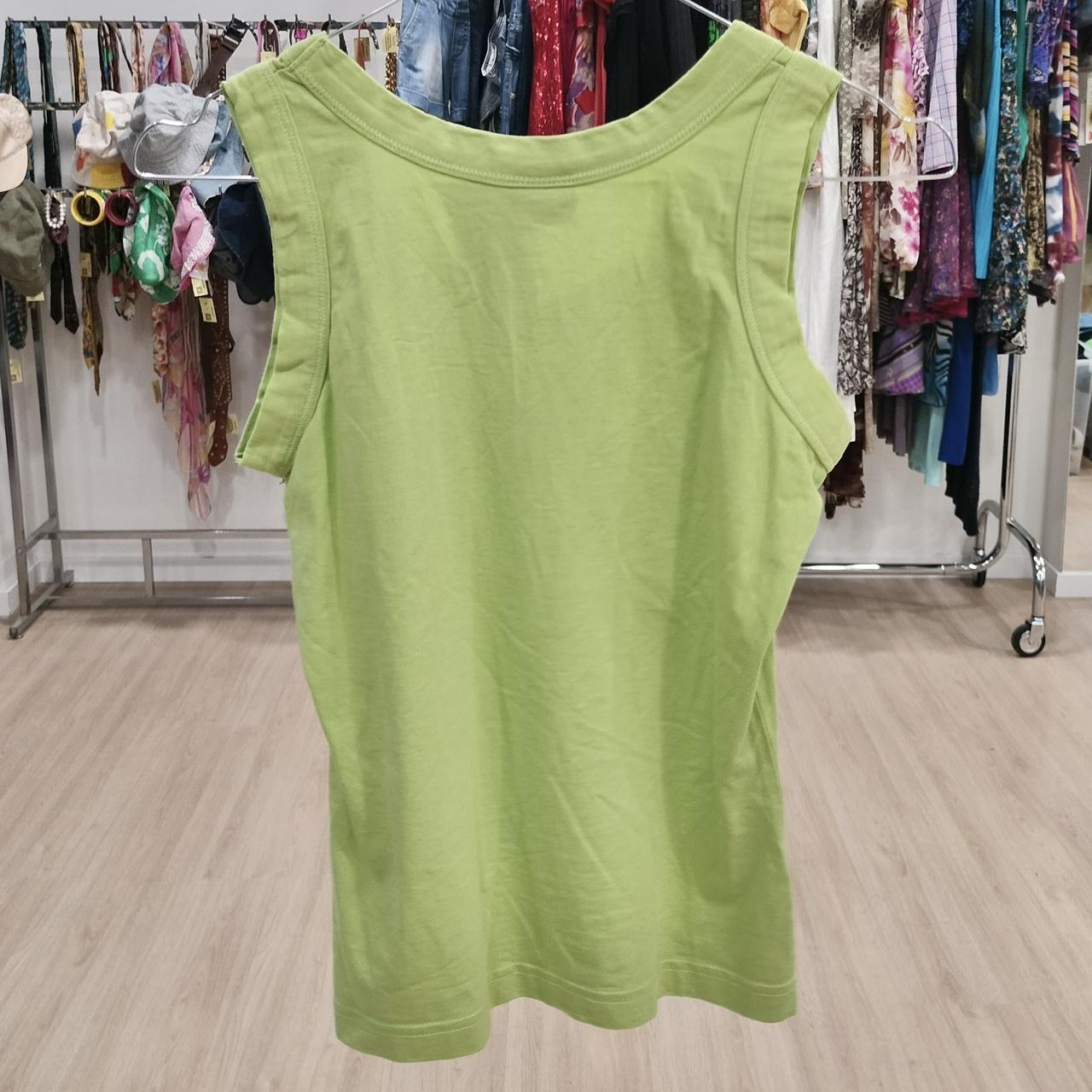 Lime green sleeveless cotton top displayed in a second hand clothing store