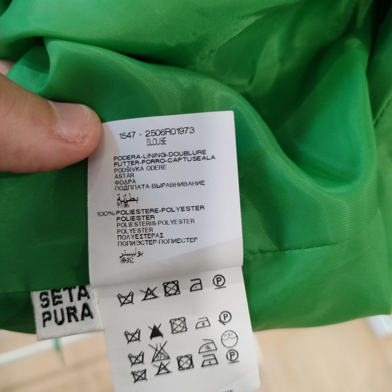 Clothing label on a green garment with care instructions