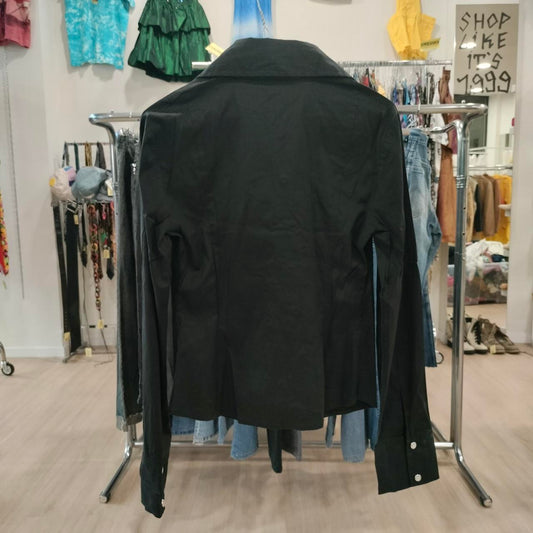 Black jacket on a rack in a clothing store with various items in the background