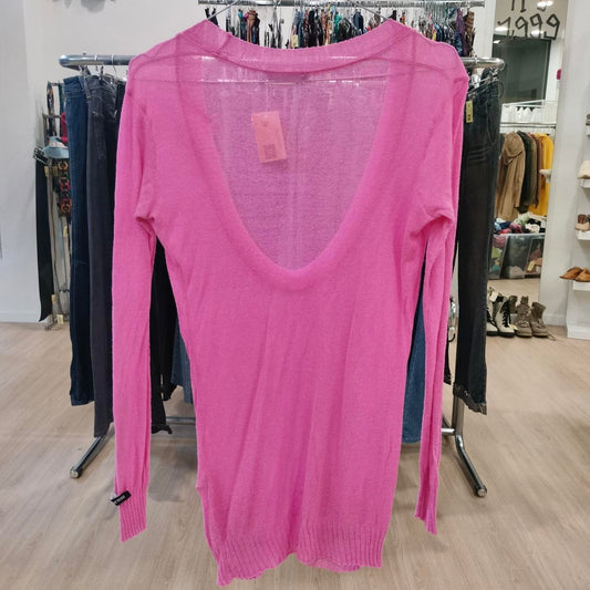 Pink sweater on a rack in a store setting with a price tag