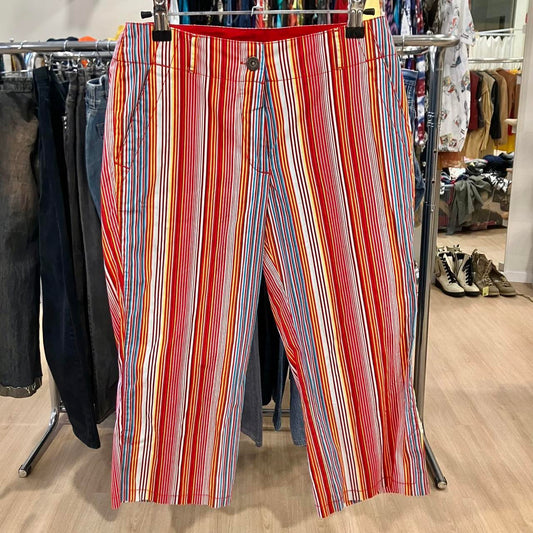 Colorful striped pants with red, orange, blue, and white vertical lines hanging in a store