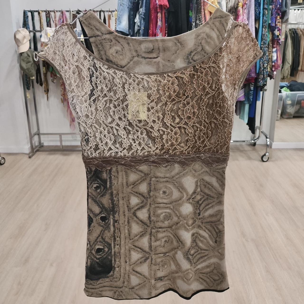 Patterned dress with lace details on a hanger in a store setting