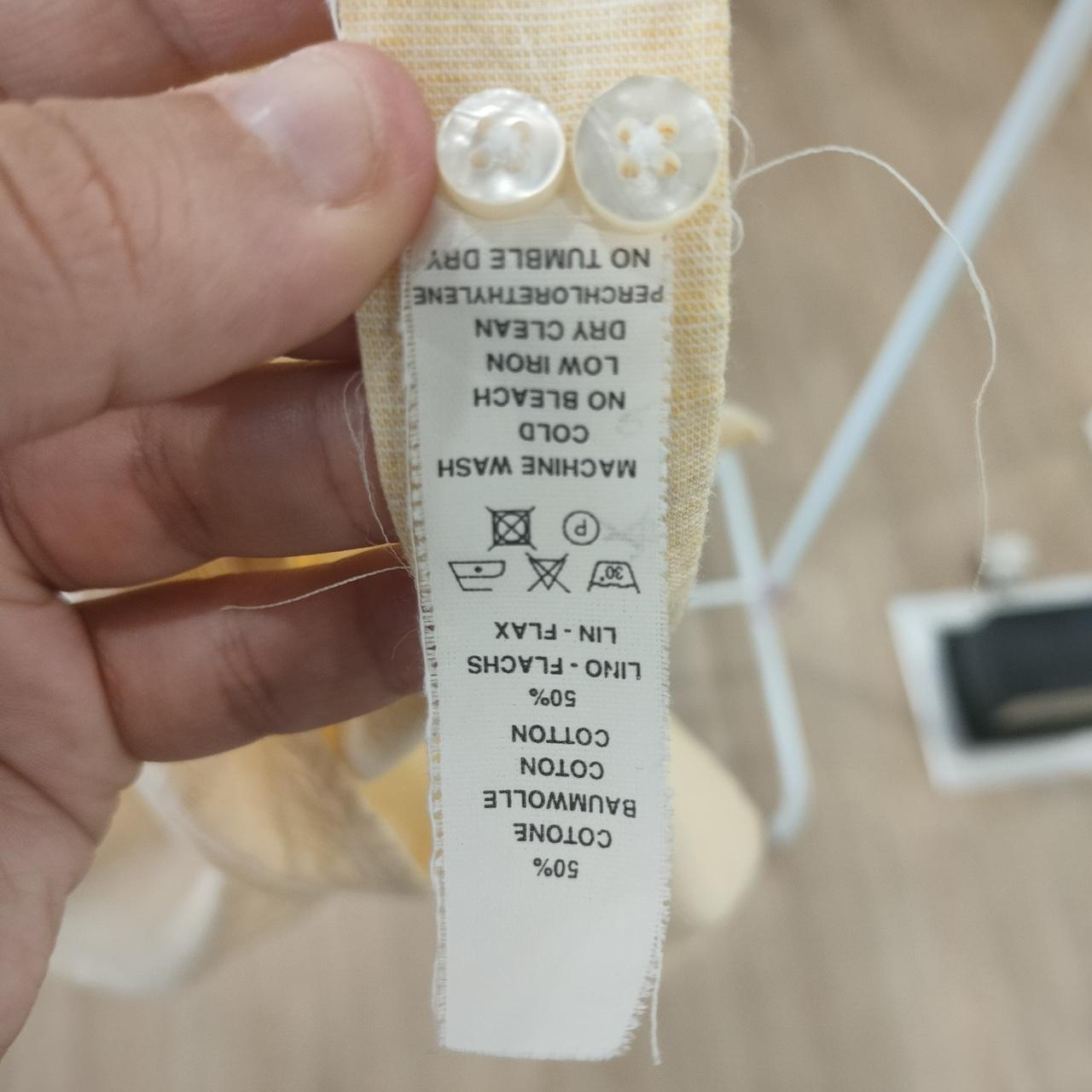 Clothing label held by a hand with a blurred background