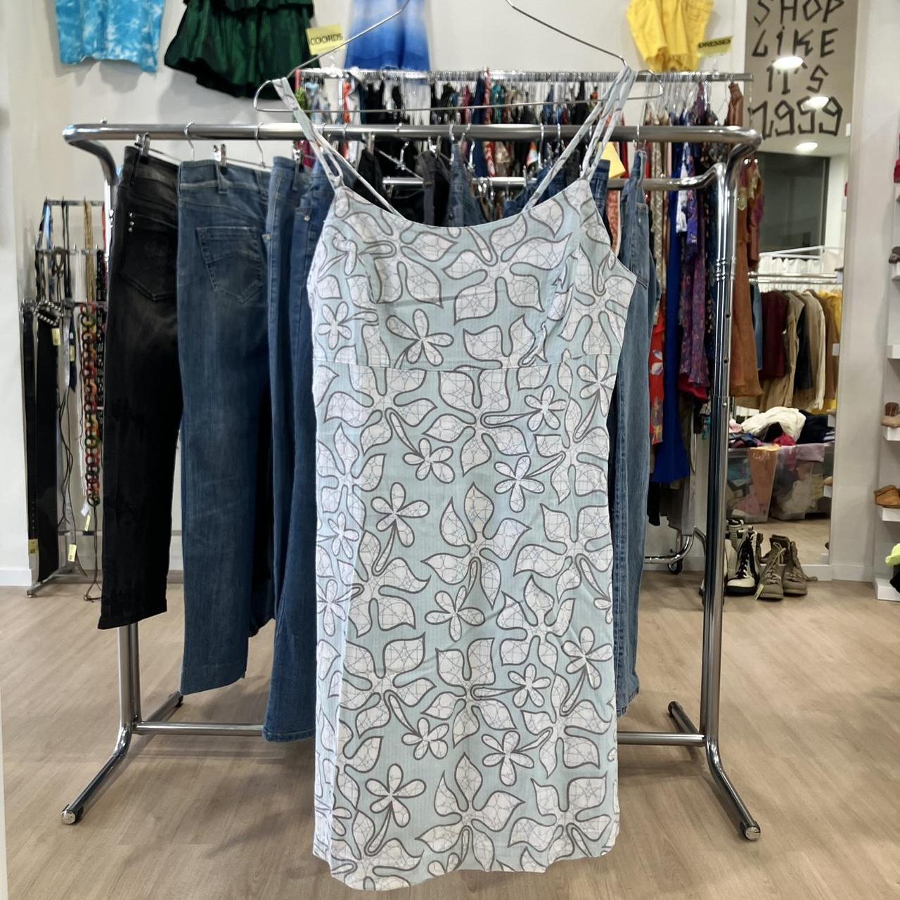 Floral patterned dress hanging on a rack in a store setting