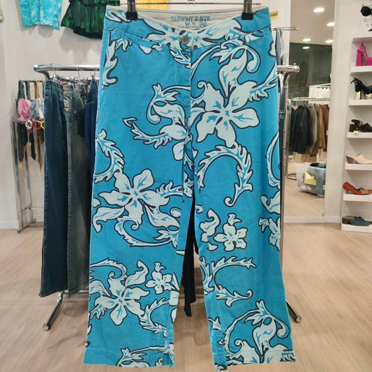 Blue floral-patterned pants hanging on a rack in a store setting