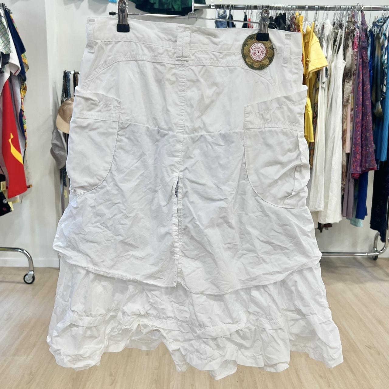 White ruffled tiered skirt with large pockets, sustainable second hand fashion on hanger