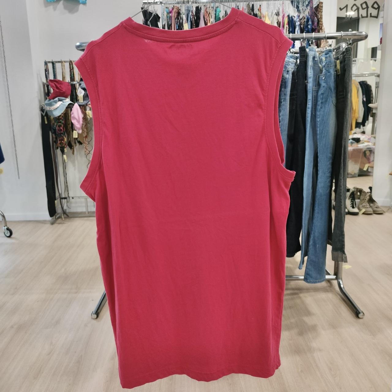 Red sleeveless top on a rack in a clothing store