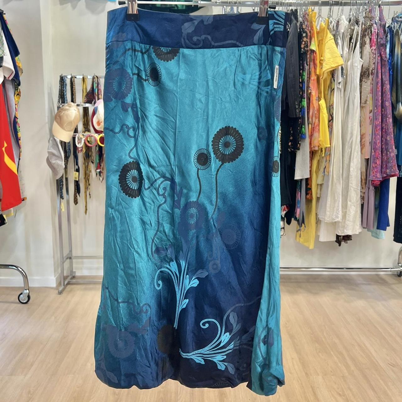 Blue skirt with floral patterns hanging on a rack in a store
