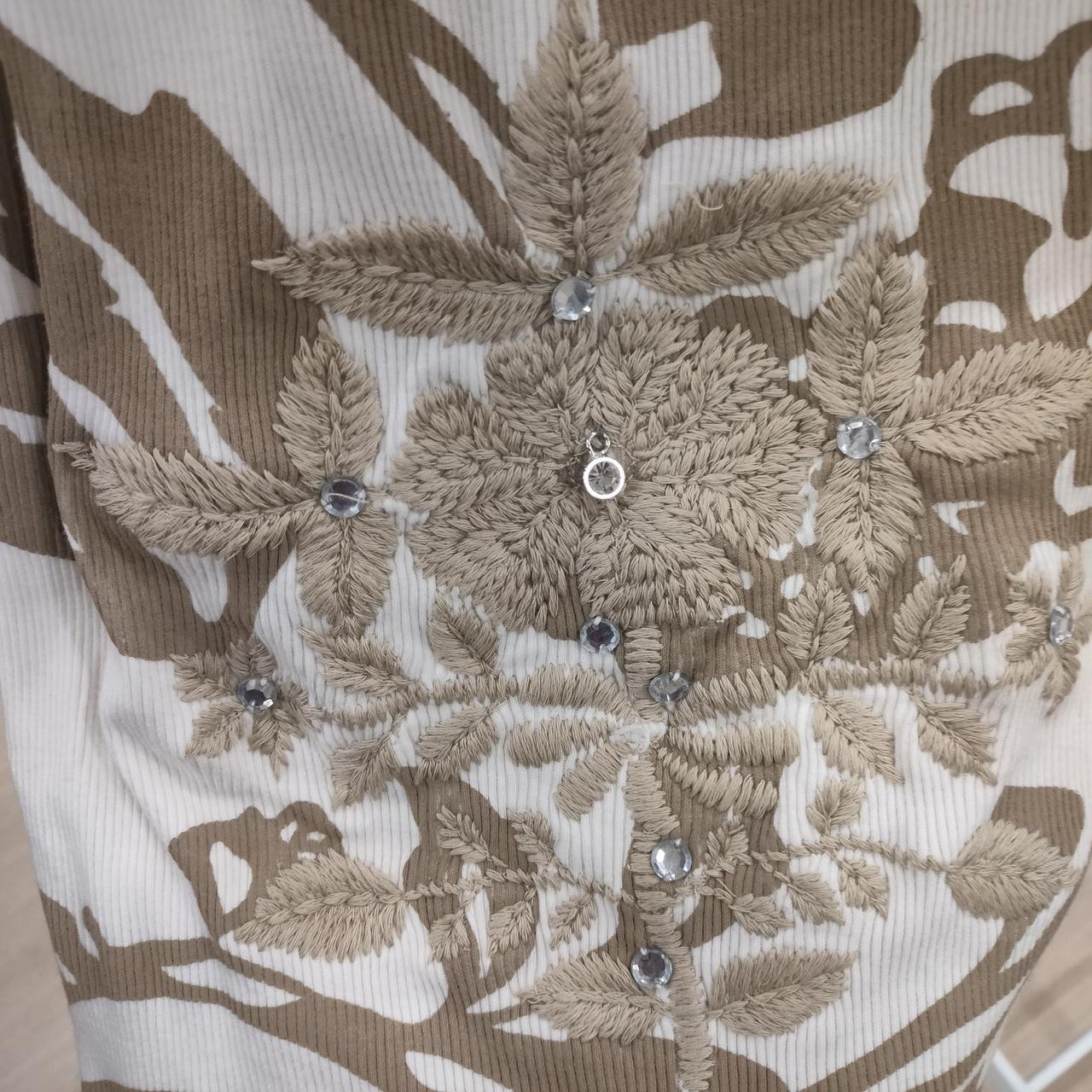 Beige floral embroidery with crystal embellishments on ribbed fabric, sustainable fashion detail