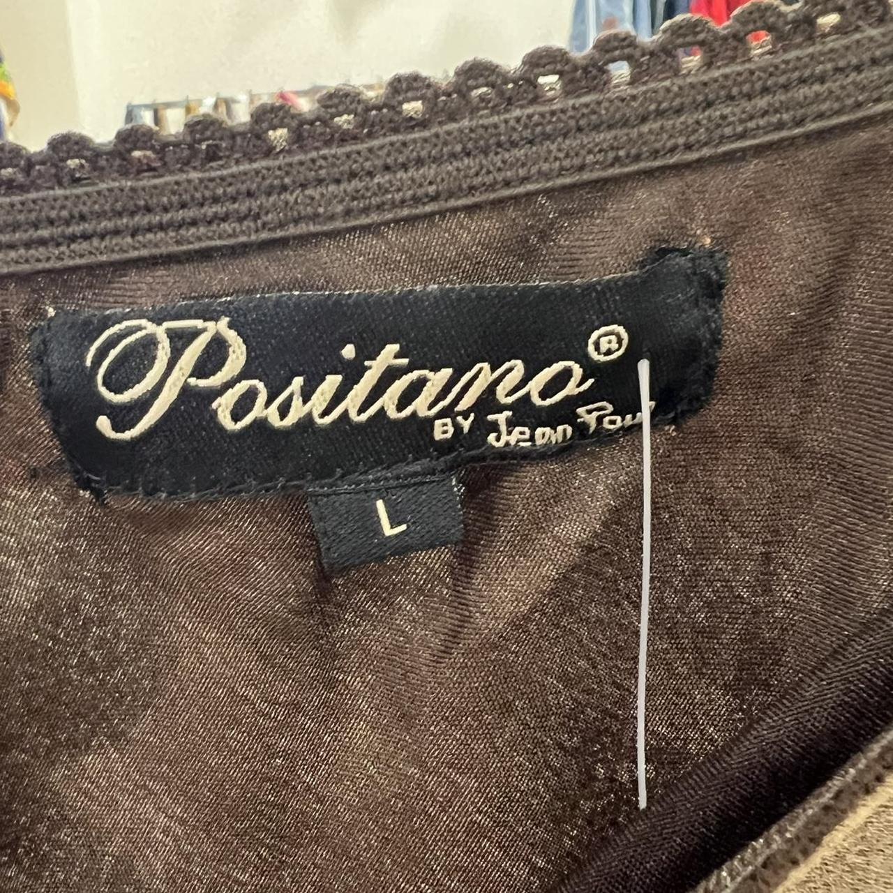 Label with 'Positano by Jean Paul' on a brown fabric background