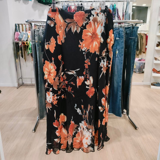 Black floral skirt with orange and white flowers hanging in a fashion boutique