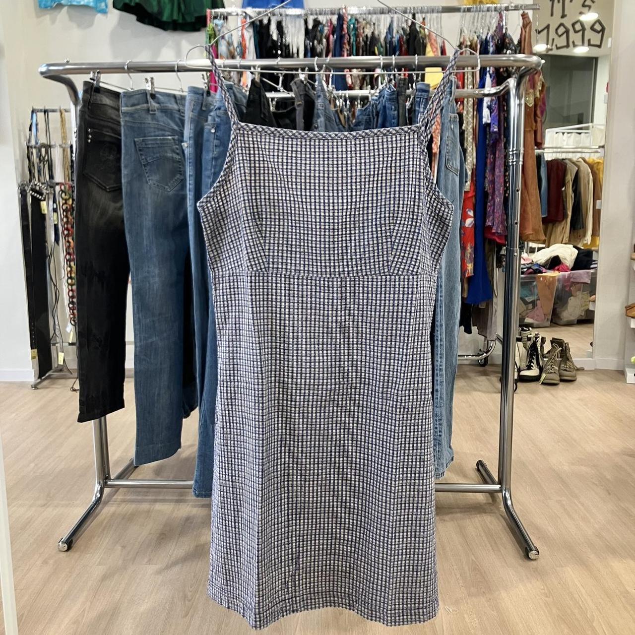 Plaid dress hanging on a clothing rack in a store setting