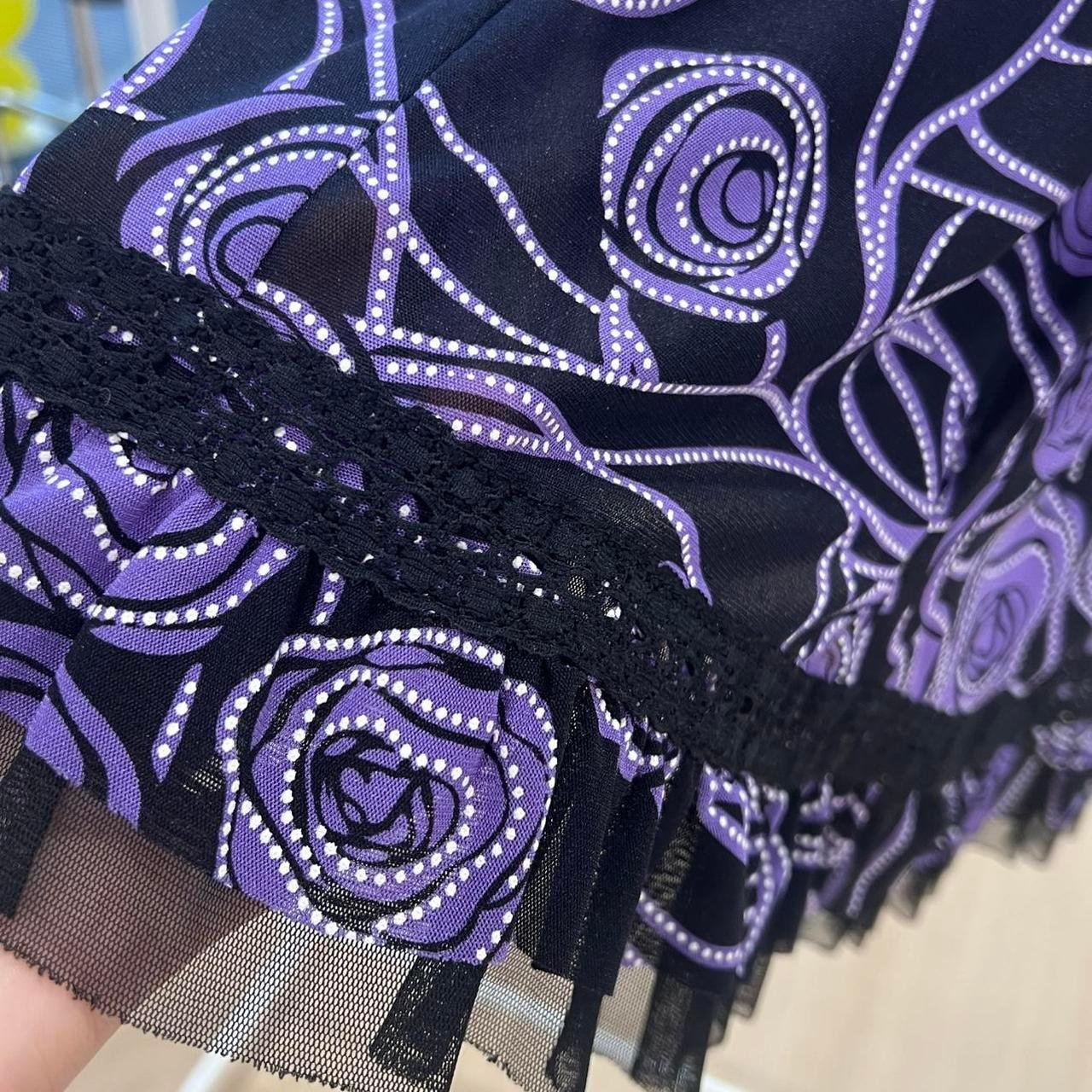 Close up of black and purple floral patterned fabric with lace and mesh trim