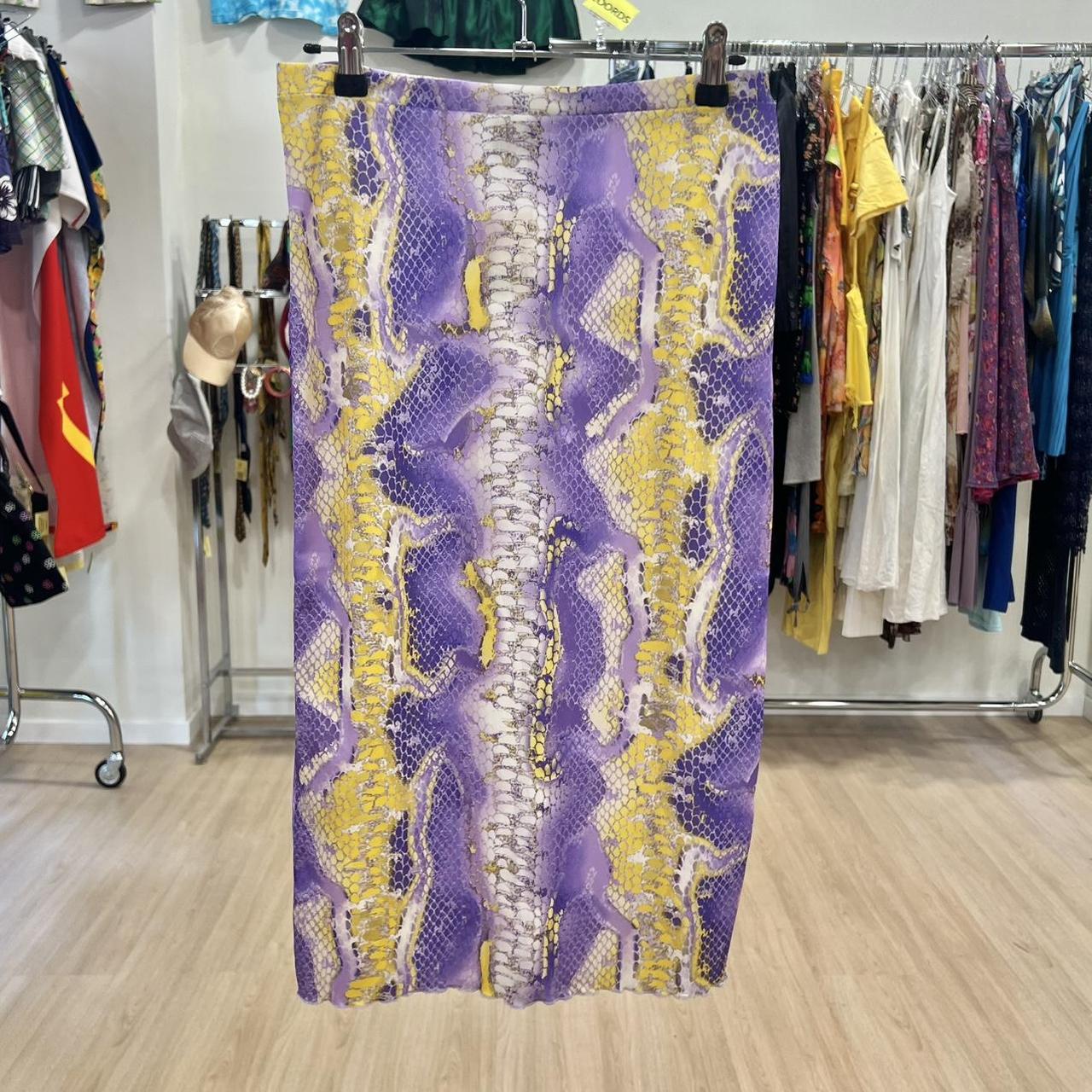 Purple and yellow patterned fabric hanging on a rack in a clothing store