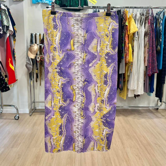 Purple and yellow patterned fabric hanging on a rack in a clothing store