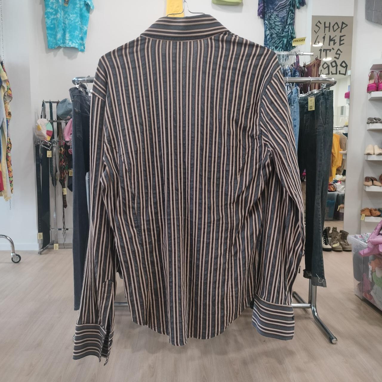 Striped shirt on a rack in a store setting with various items in the background
