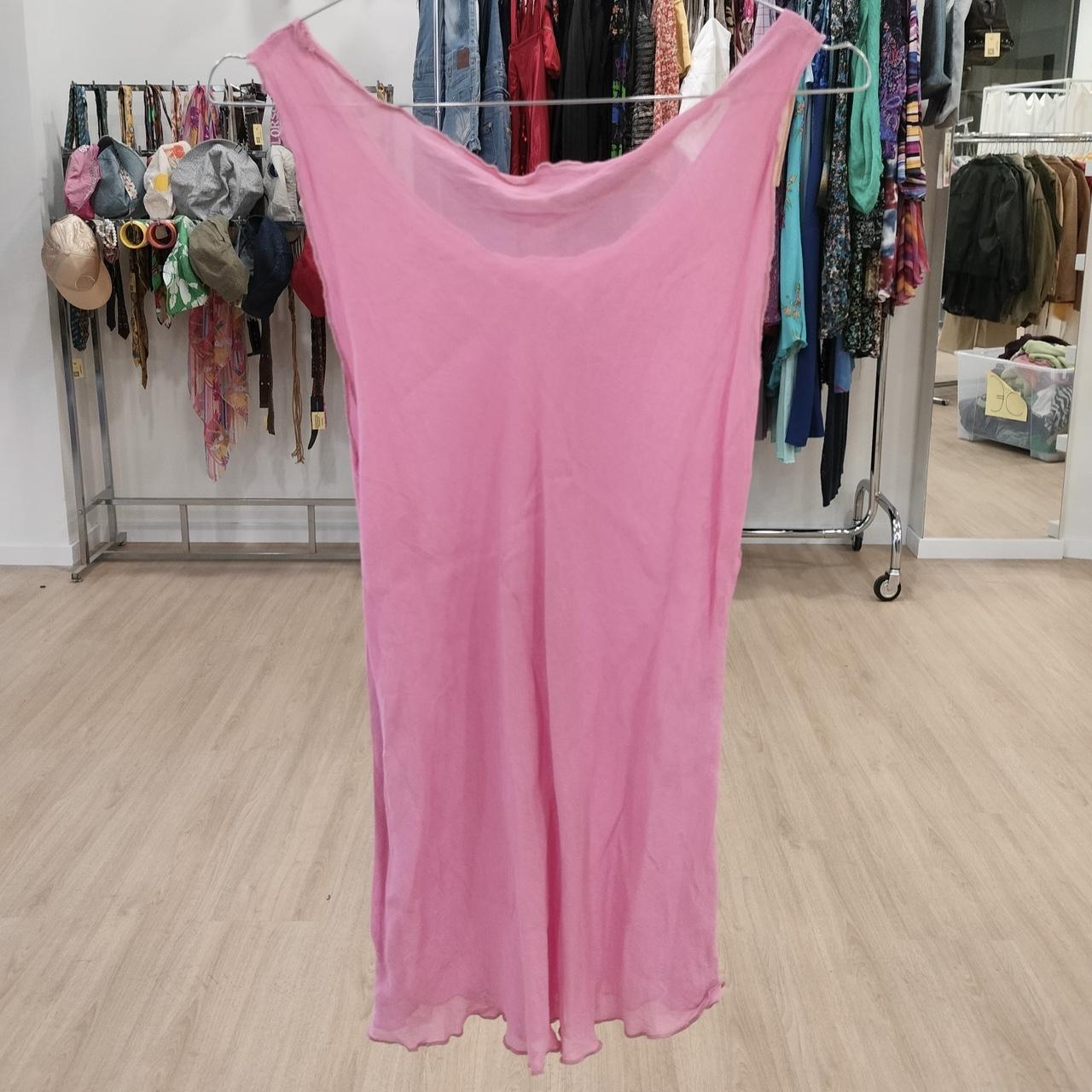 Pink sheer sleeveless dress displayed in a second hand clothing store