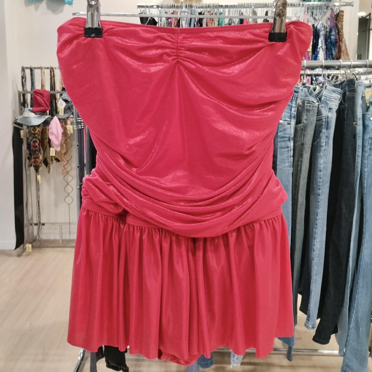 Pink strapless dress hanging on a rack in a store setting