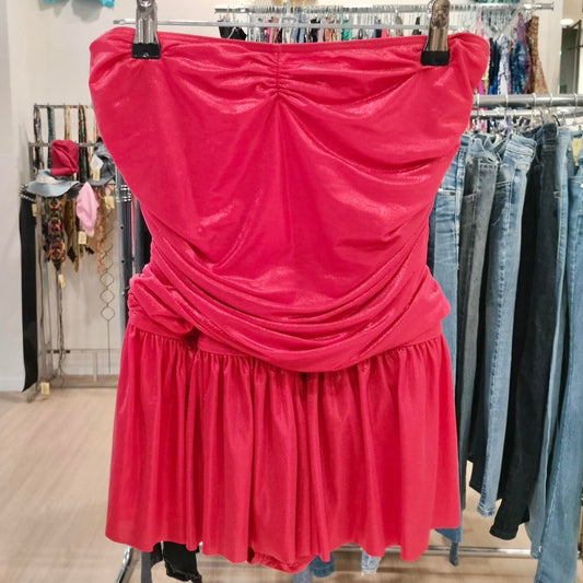 Pink strapless dress hanging on a rack in a store setting