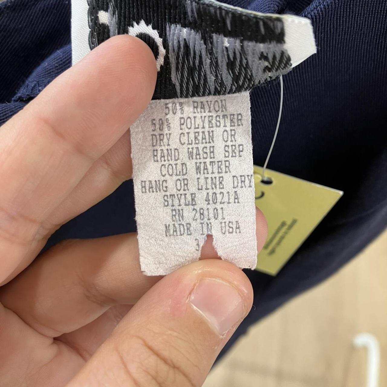 Clothing tag with fabric composition and care instructions held by a hand
