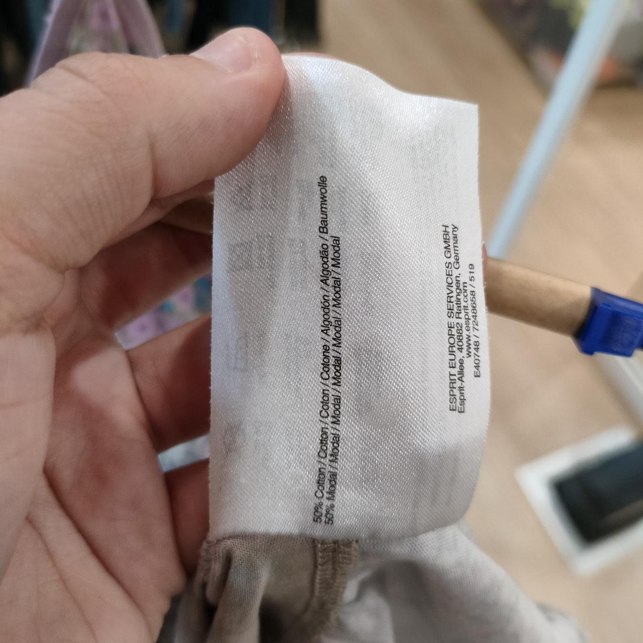 Close-up of sustainable fashion garment care label showing cotton and modal fabric blend