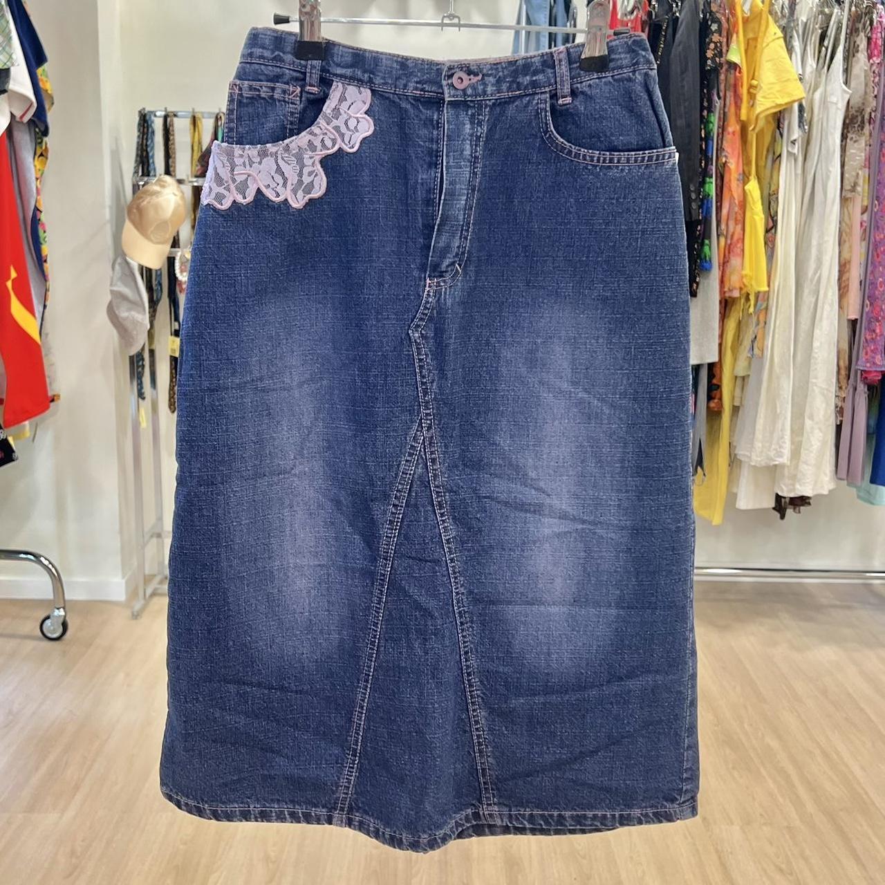 Blue denim skirt with lace trim on a hanger in a clothing store