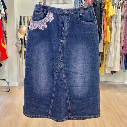 Blue denim skirt with lace trim on a hanger in a clothing store