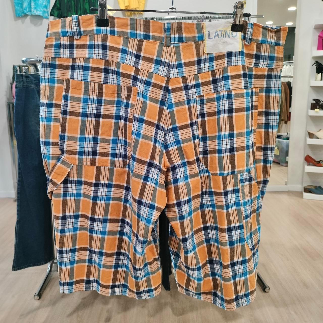Orange blue plaid cargo shorts with back pockets on display in a second hand fashion store