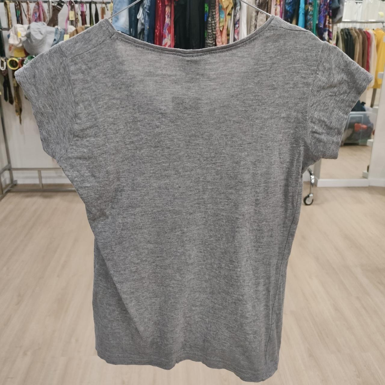 Gray short sleeve t-shirt displayed in a second hand clothing store