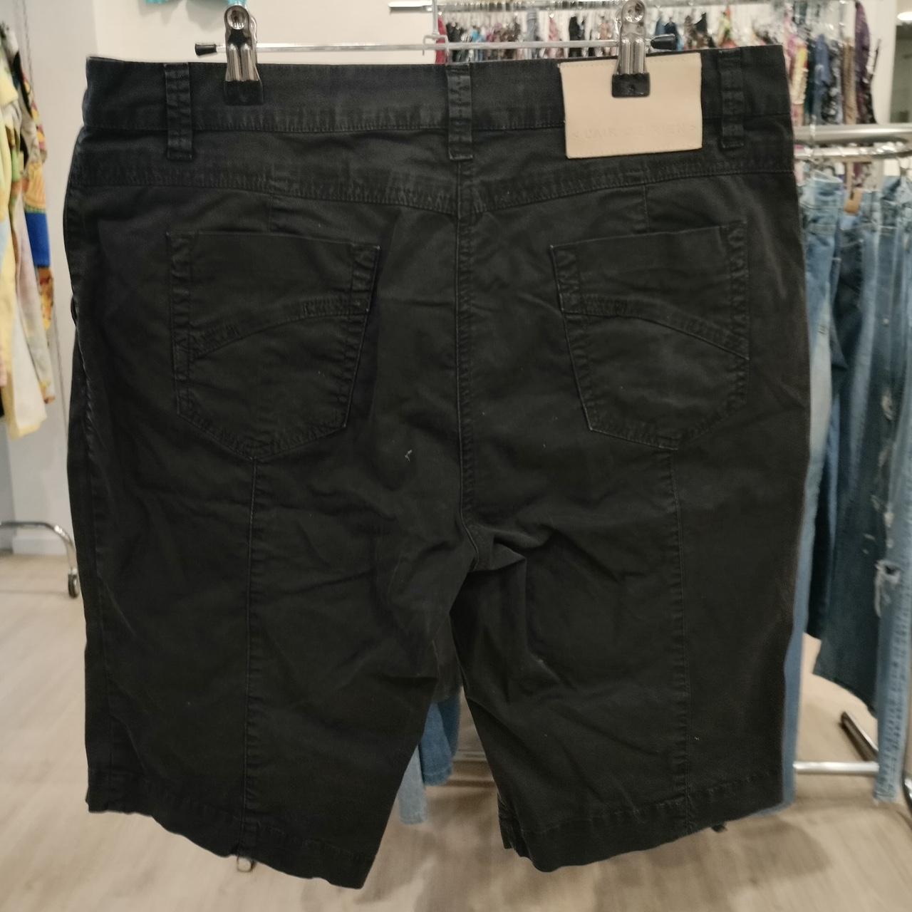 Black denim shorts with back pockets displayed in a second hand clothing store
