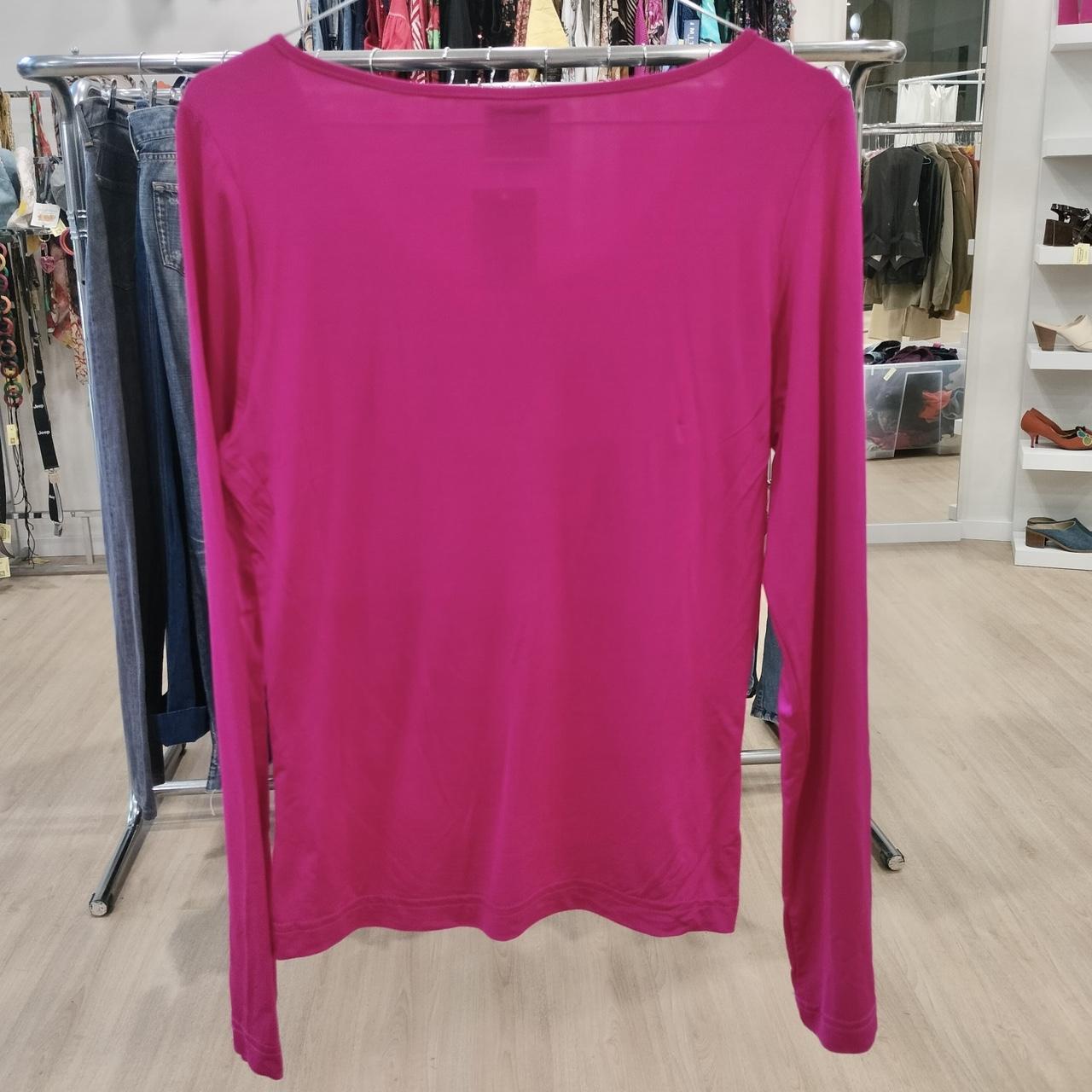 Pink long-sleeve shirt on a hanger in a store setting