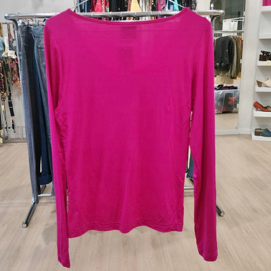 Pink long-sleeve shirt on a hanger in a store setting