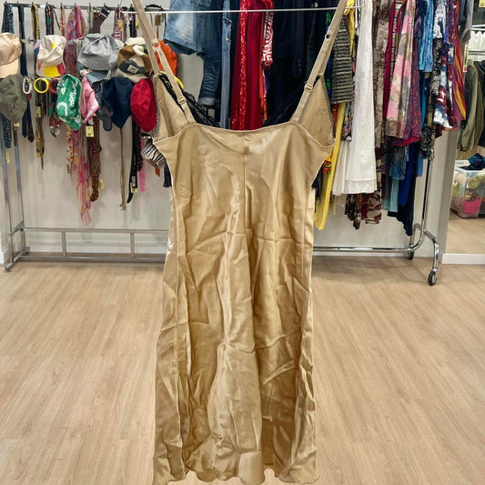 Beige satin slip dress with adjustable straps, displayed in a second hand fashion store.