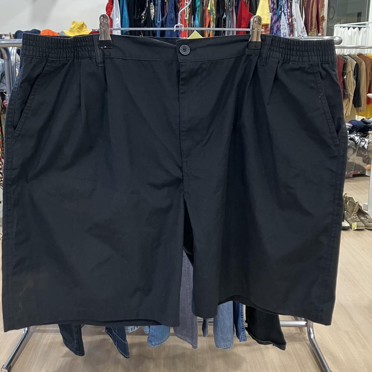 Black shorts hanging on a rack with a clothing store background