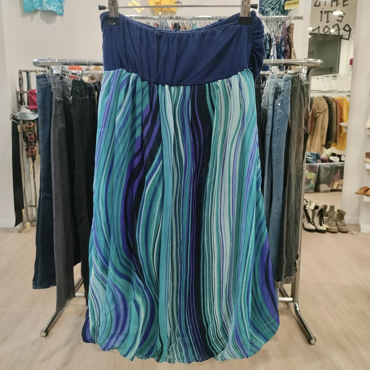 Blue and teal striped flowy skirt hanging in a second hand clothing store