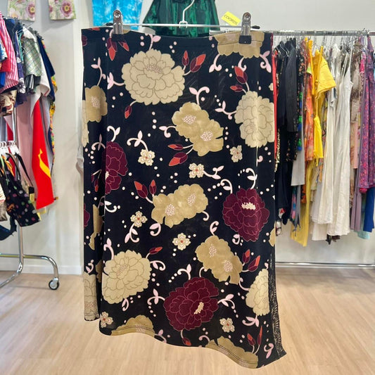 Floral patterned skirt hanging on a rack with other clothing in the background